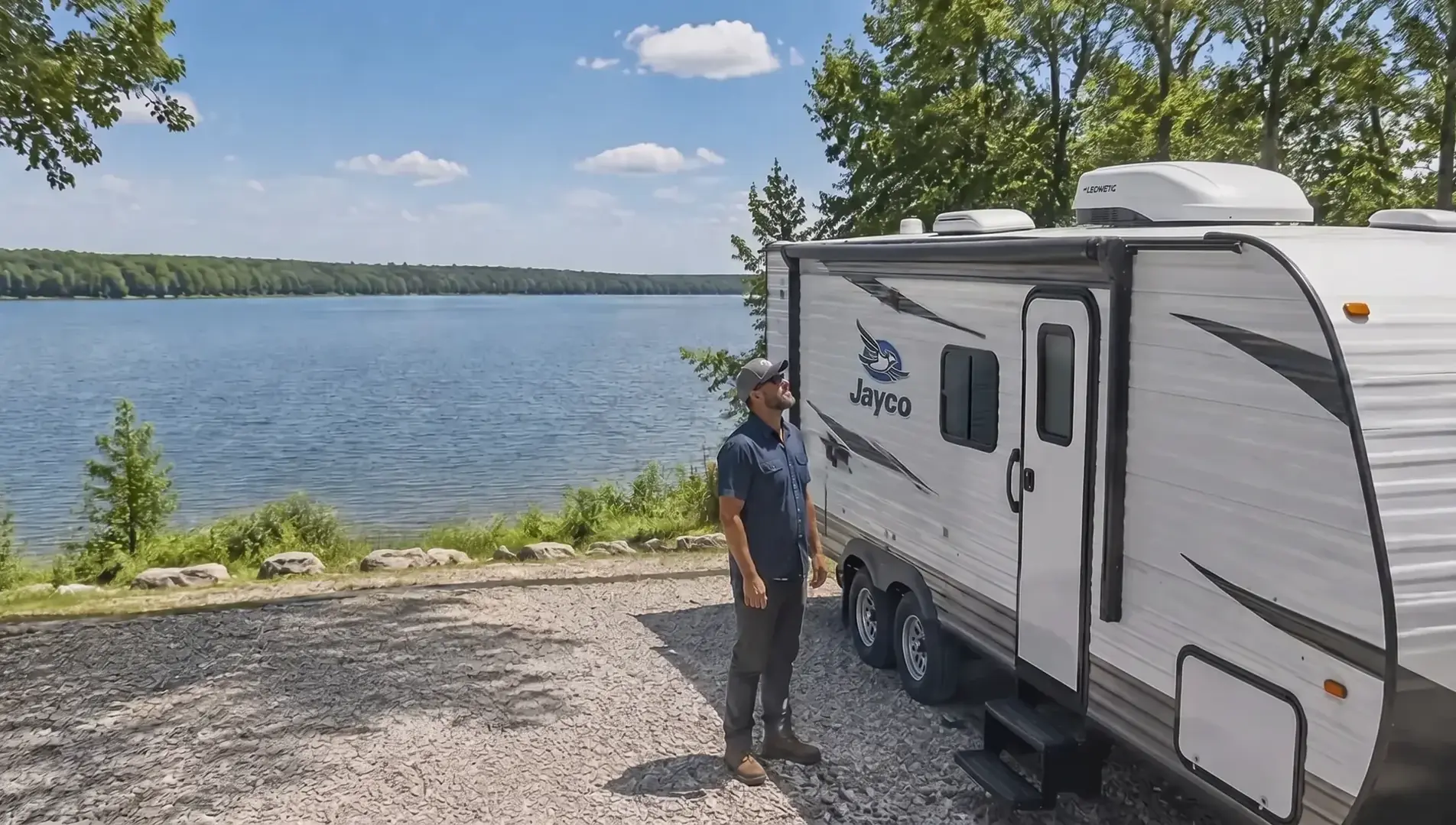 RV AC repair technician beside a travel trailer at a campsite near Longview Lake in Kansas City